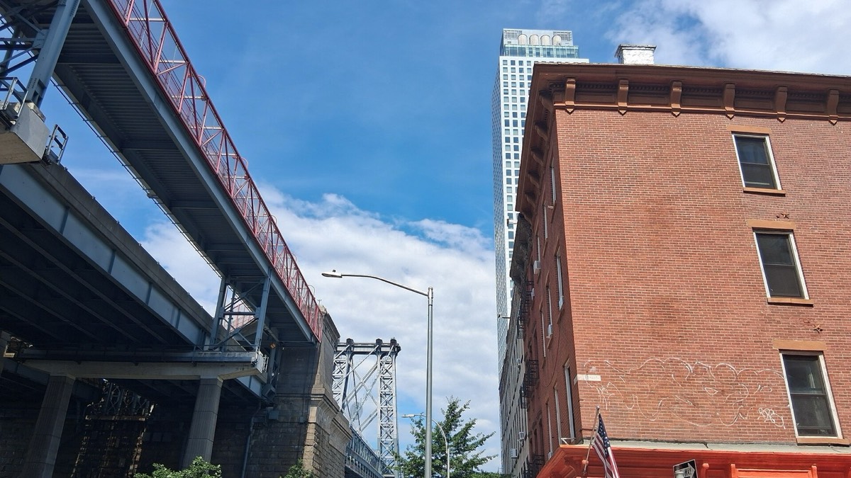 The Williamsburg Bridge beside a brick building in Williamsburg